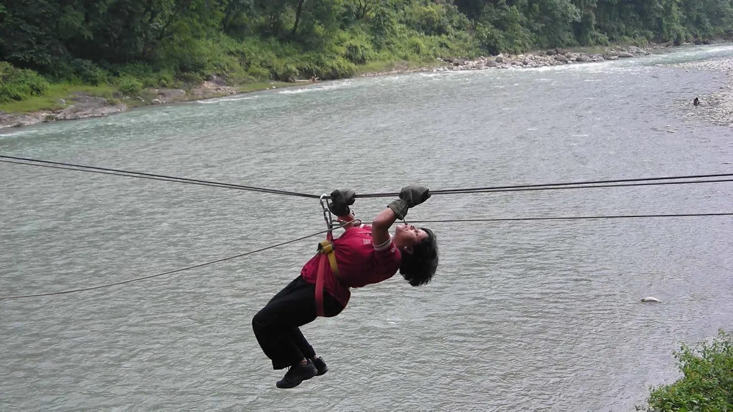 Outdoor team crossing a Himalayan river