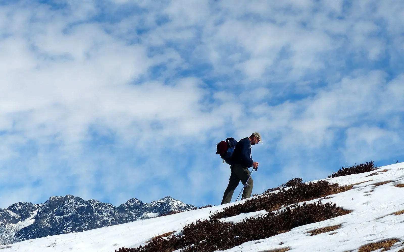 A hiker ascending a snow-covered slope in Uttarakhand